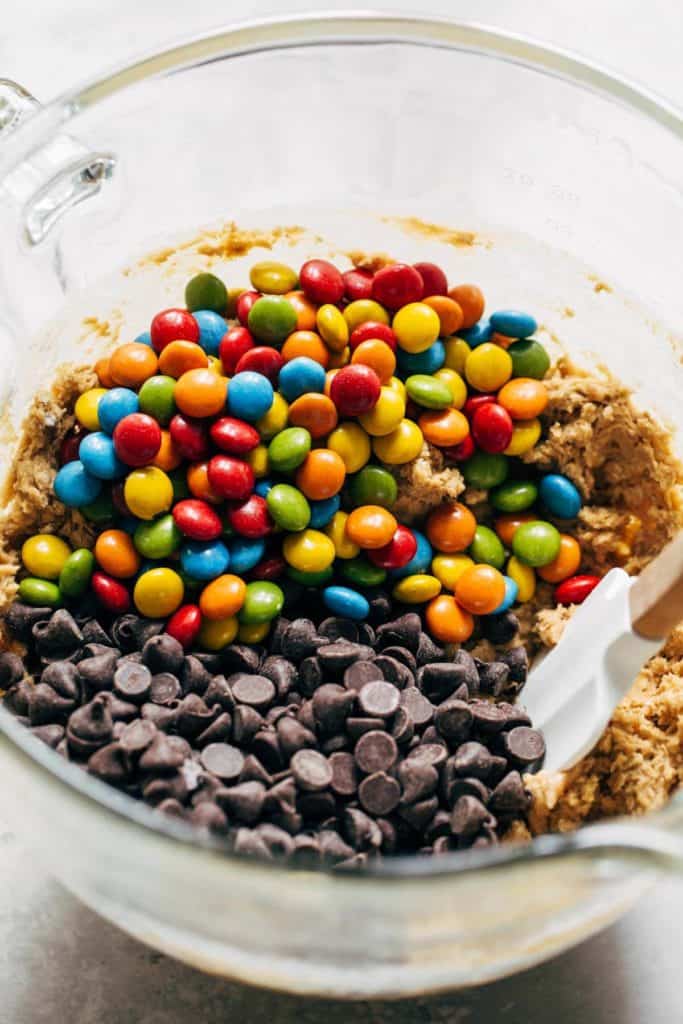 a bowl of cookie dough with chocolate candies and chocolate chips