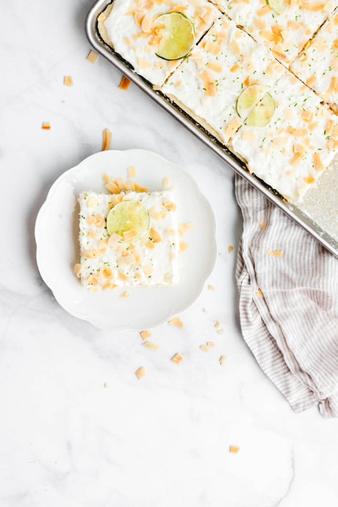 A piece of lime and coconut sheet cake on a plate.