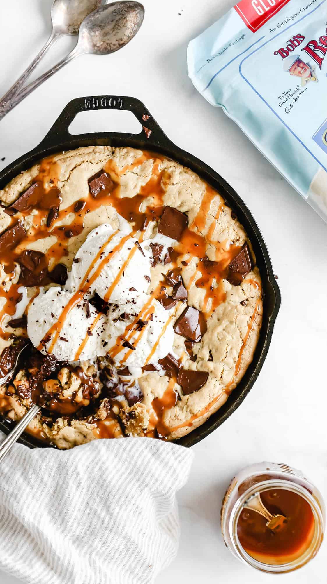 a gluten free skillet cookie with ice cream and caramel on top