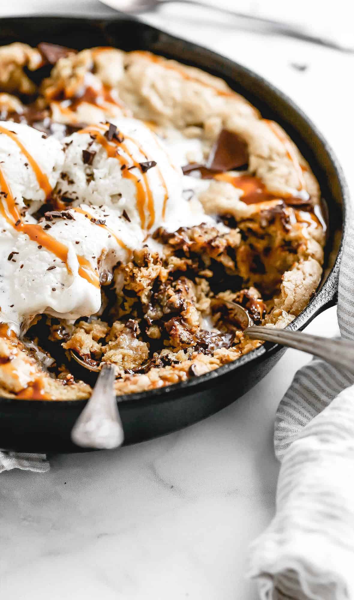 a gluten free skillet cookie with ice cream and caramel on top