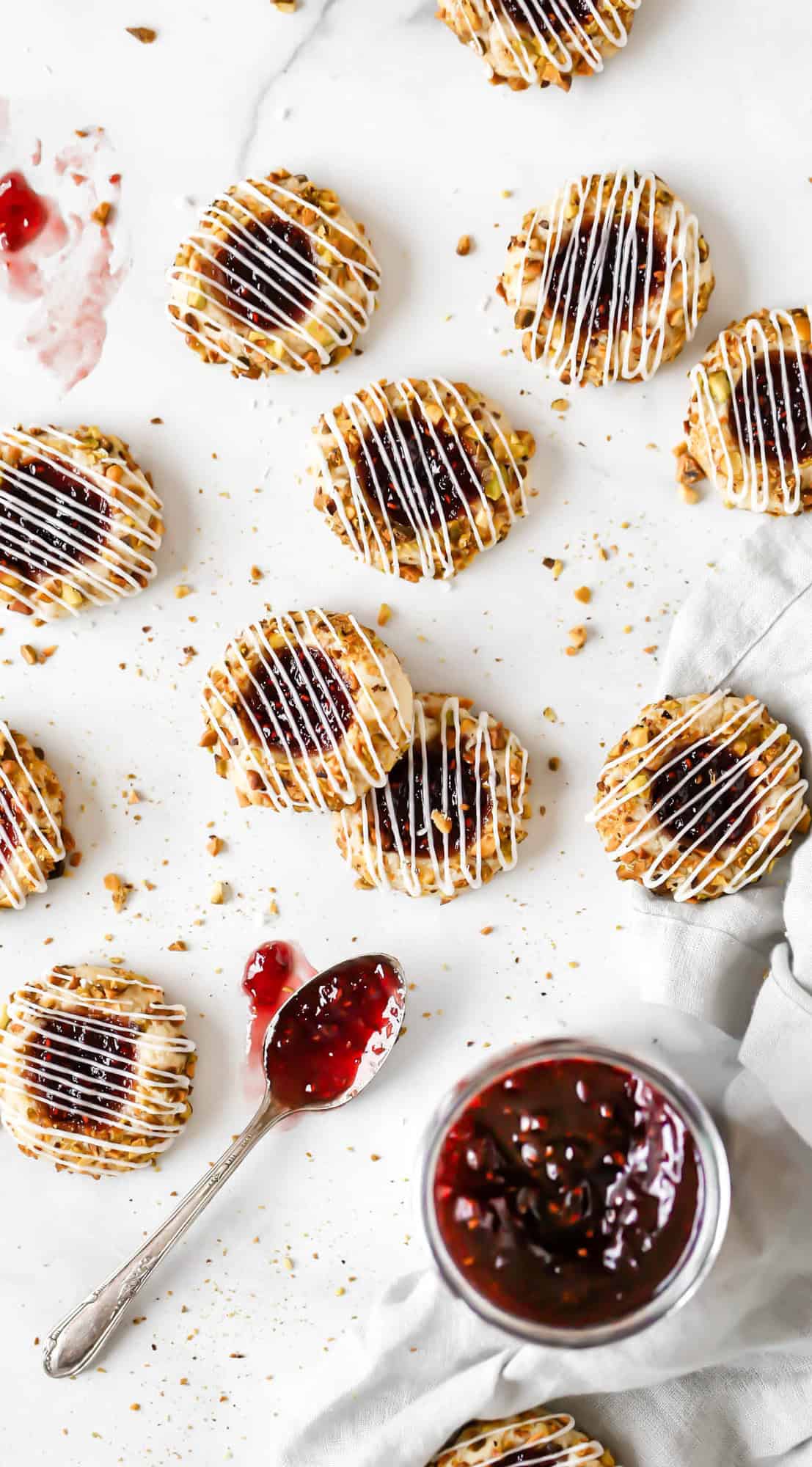 pistachio and raspberry thumbprint cookies on a marble slab
