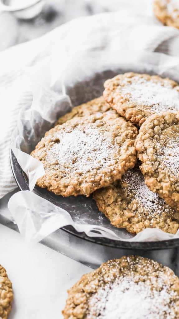 a tray of chewy oatmeal cookies topped with powdered sugar