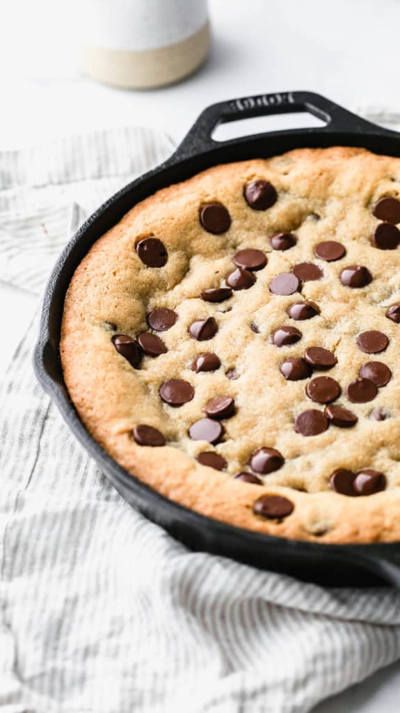 a deep dish chocolate chip cookie baked in a cast iron skillet