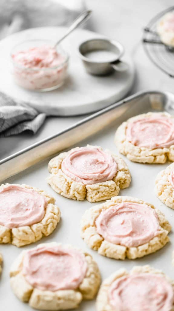 soft frosted sugar cookies on a baking tray