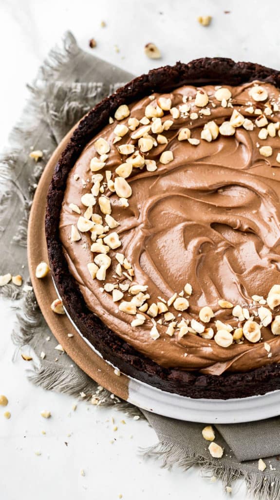 a whole nutella pie with chopped hazelnuts on top