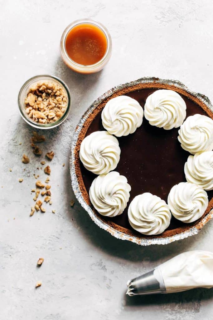 a chocolate pie with swirls of whipped cream on top