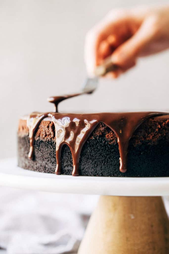 chocolate ganache dripping off the side of a cheesecake