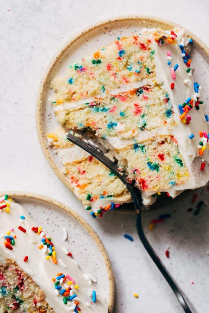 a slice of funfetti cake on a ceramic plate