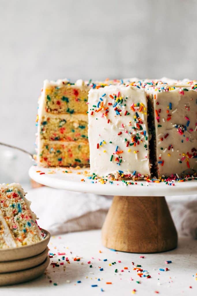 a sliced funfetti layer cake on a cake stand