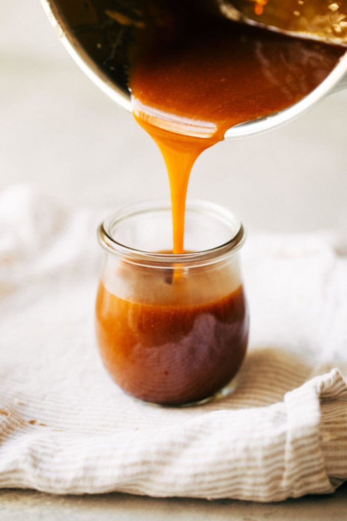 pouring salted caramel into a jar