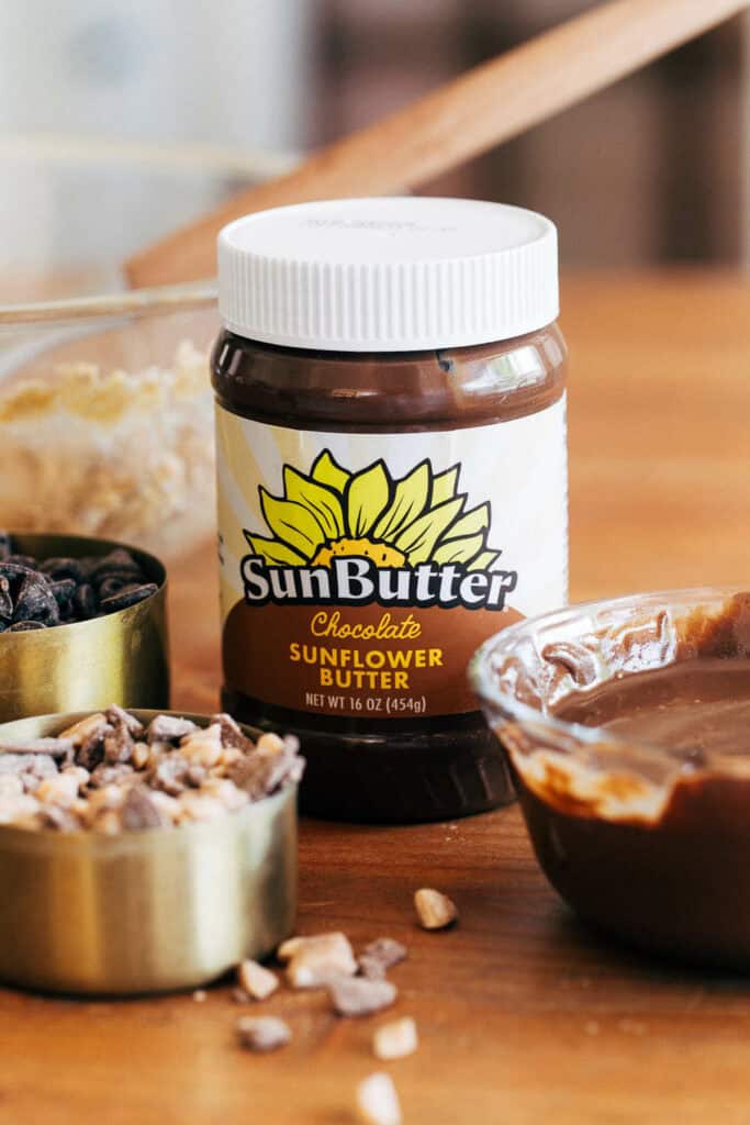 a jar of chocolate sunbutter with crumble bar ingredients