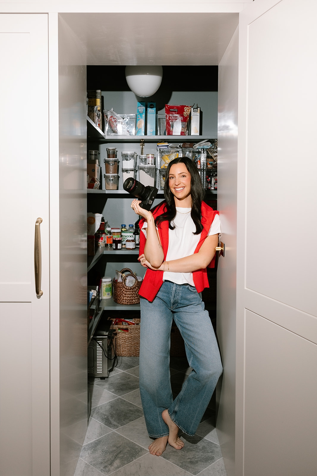 Jenna holding a camera in her pantry