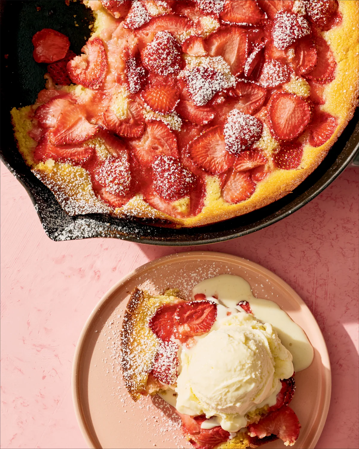 Strawberry spoon cake served in a skillet and on a plate with ice cream