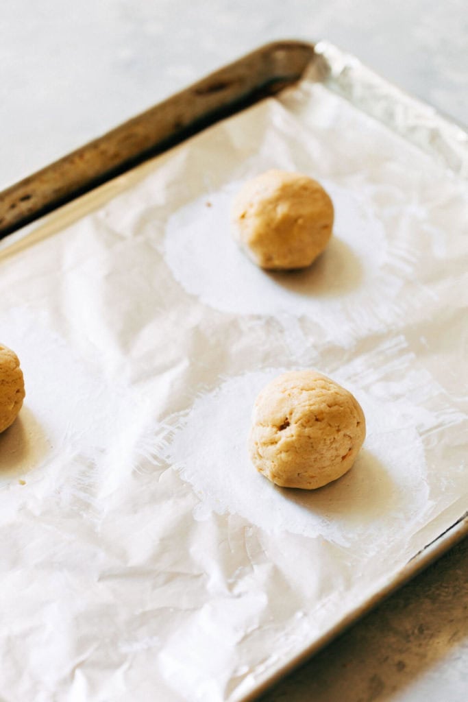 peanut butter cookie dough balls on a baking pan lined with foil