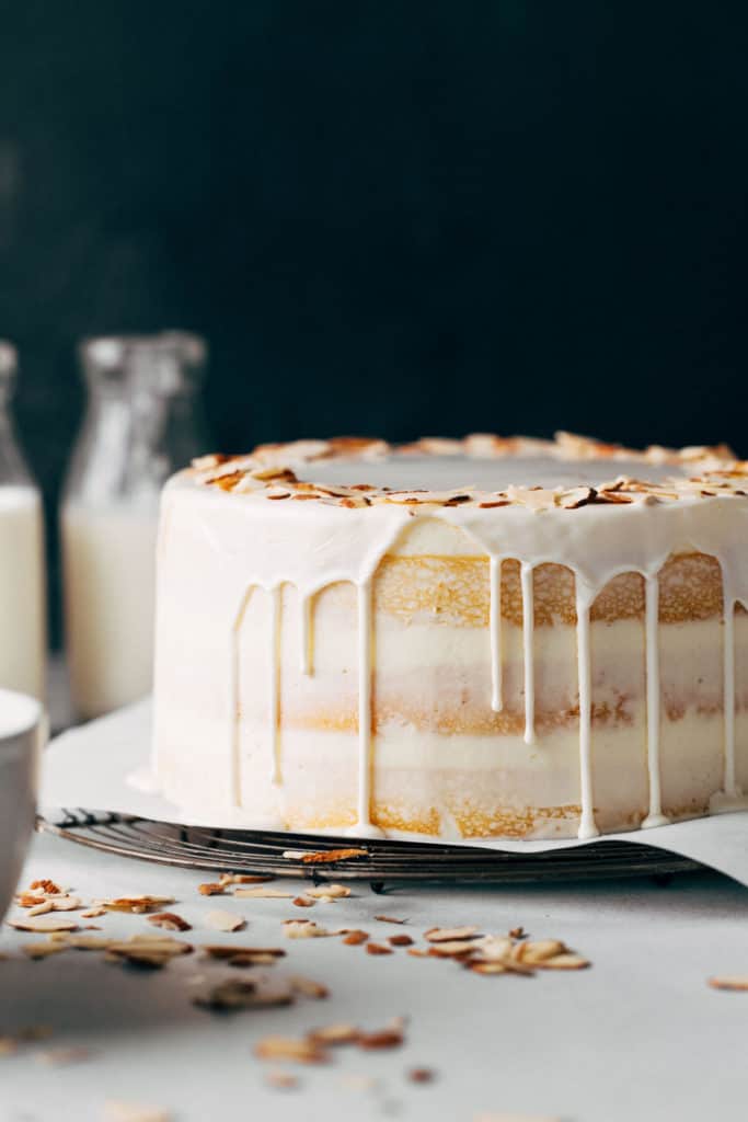 the side view of a layer cake with white chocolate dripping down the sides