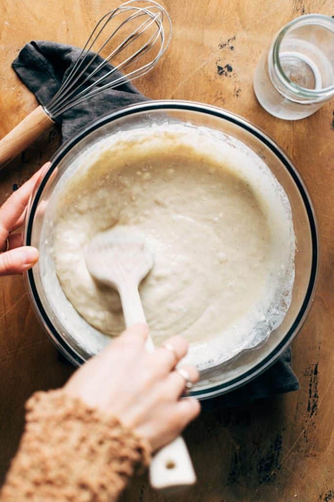 mixing a bowl of wet ingredients for cinnamon roll dough