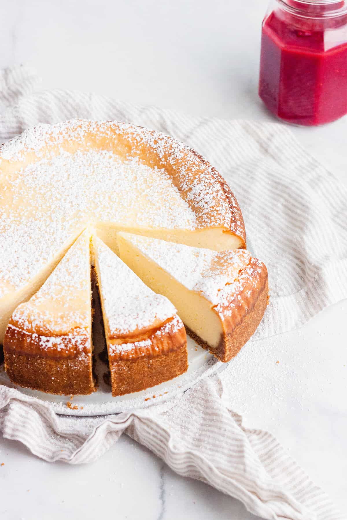 New York Cheesecake with a jar of raspberry sauce