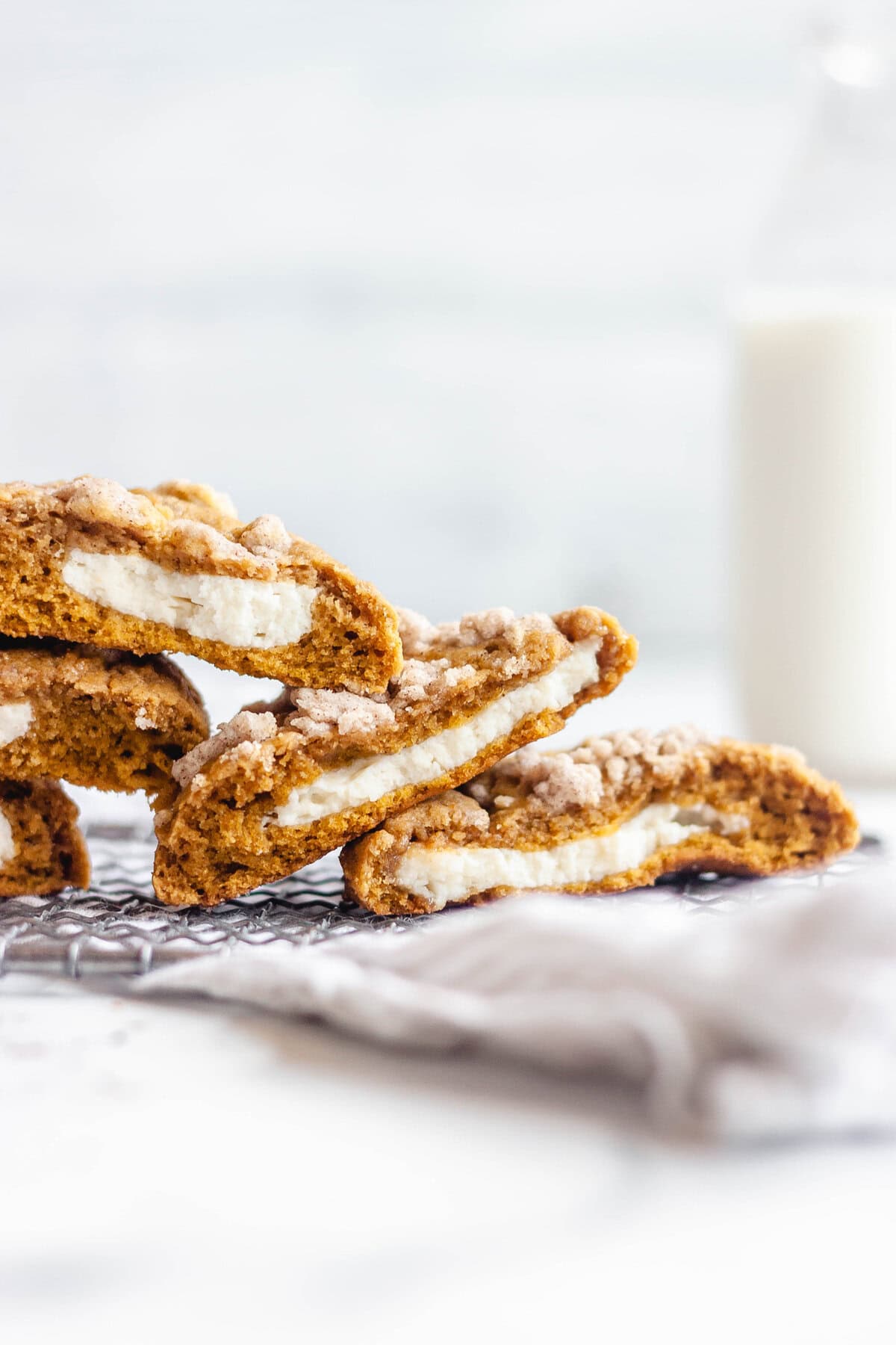 Pumpkin cheesecake cookies halfed and stacked on top of each other