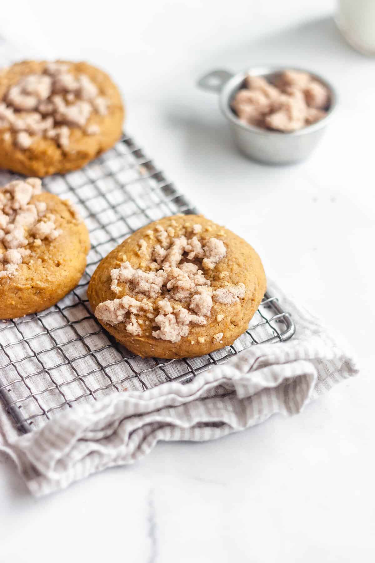 Pumpkin cheesecake cookies laying on a vintage wire cooling rack.