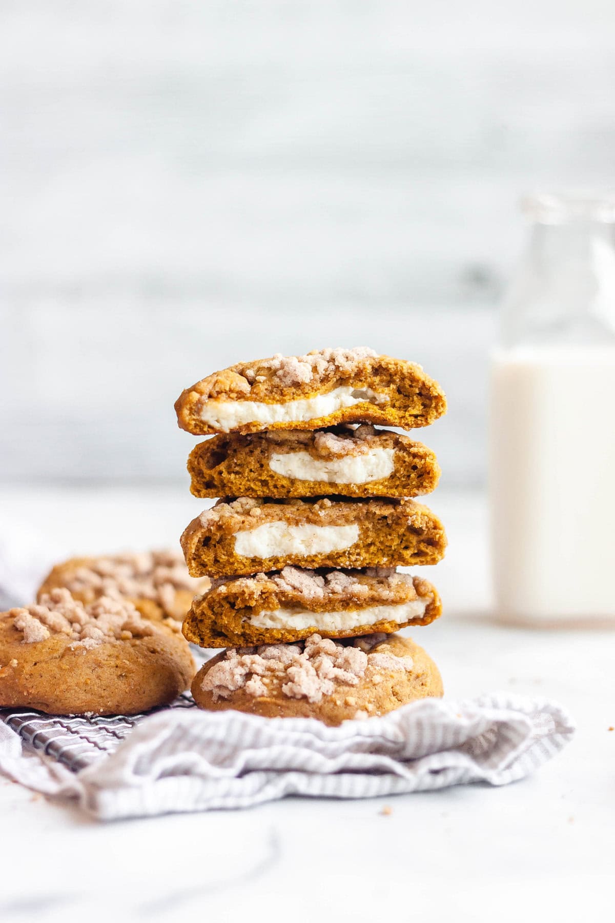 Pumpkin cheesecake cookies halfed and stacked on top of each other