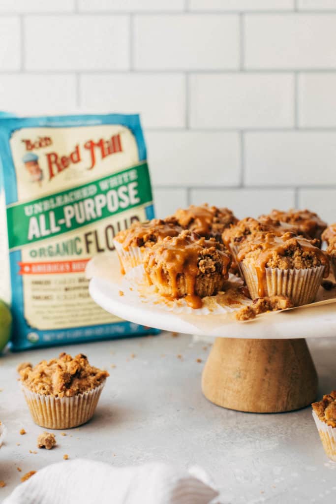 apple muffins drizzled in caramel and arranged on a cake stand