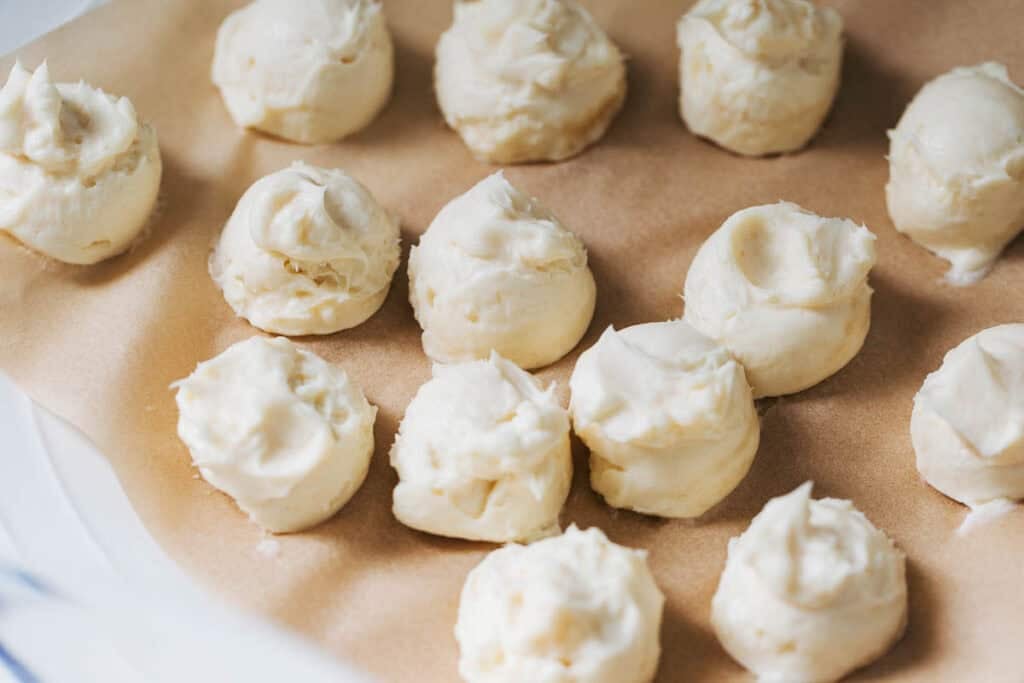 dollops of cream cheese on a plate lined with parchment paper