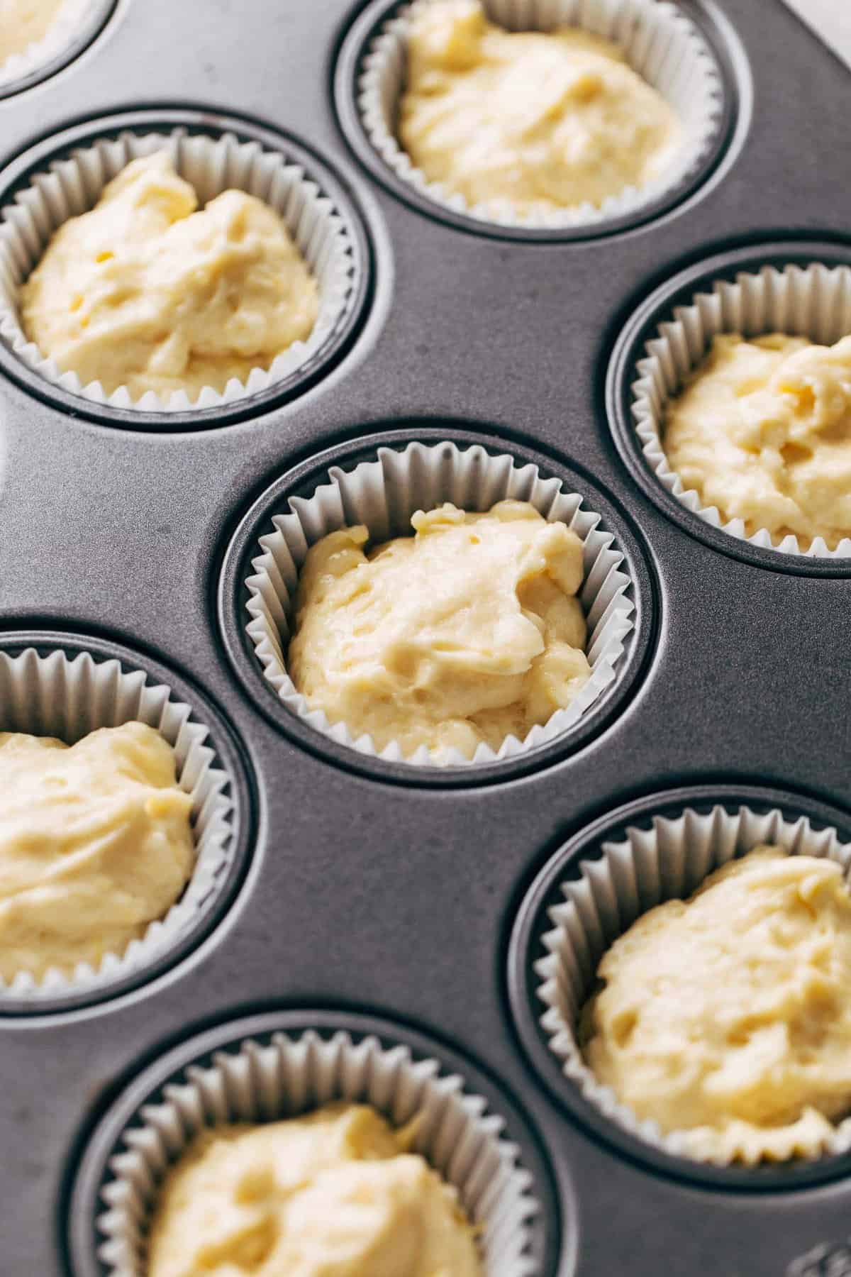 lemon cupcake batter scooped into the cupcake liners