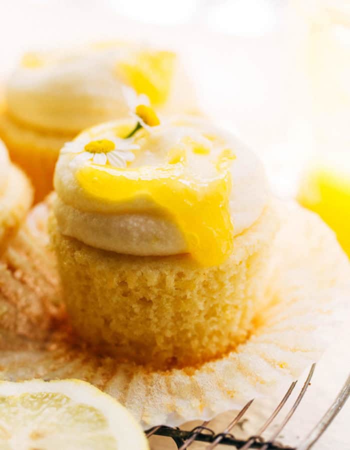 lemon curd dripping down the side of an unwrapped lemon cupcake