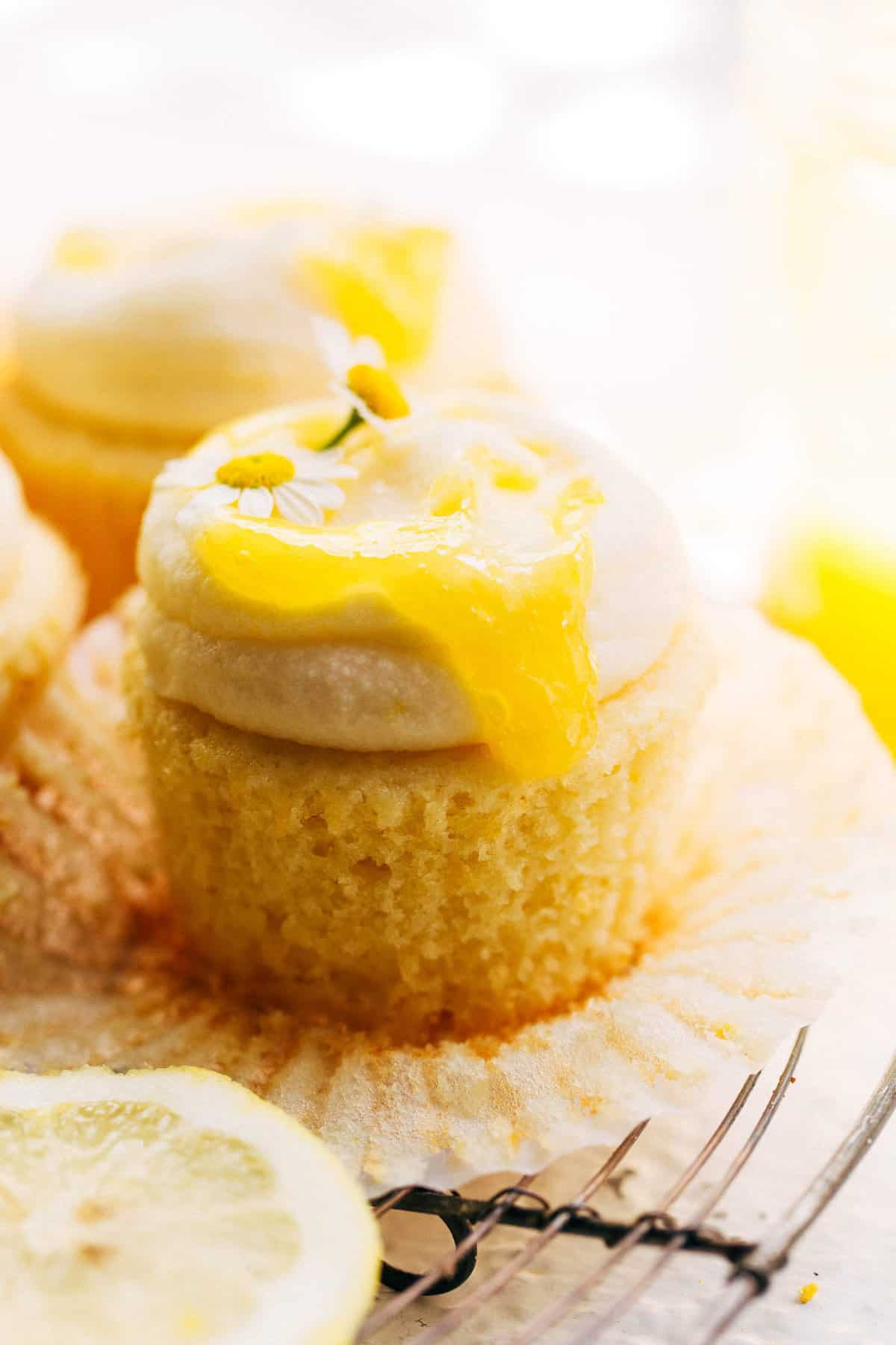 lemon curd dripping down the side of an unwrapped lemon cupcake