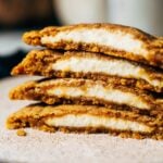 a stack of pumpkin cookies filled with cream cheese