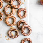apple cider crullers scattered on parchment paper
