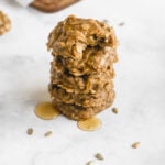 a stack of no bake sunflower seed butter cookies drizzled in honey