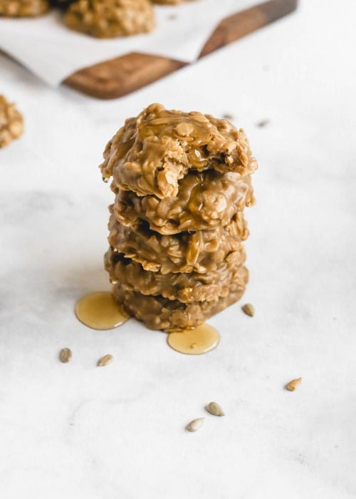 a stack of no bake sunflower seed butter cookies drizzled in honey