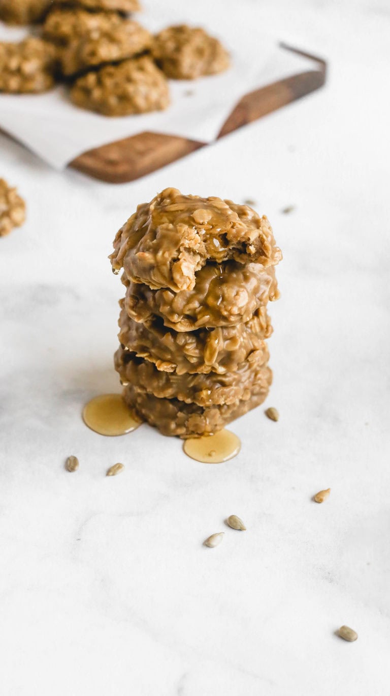 a stack of no bake sunflower seed butter cookies drizzled in honey