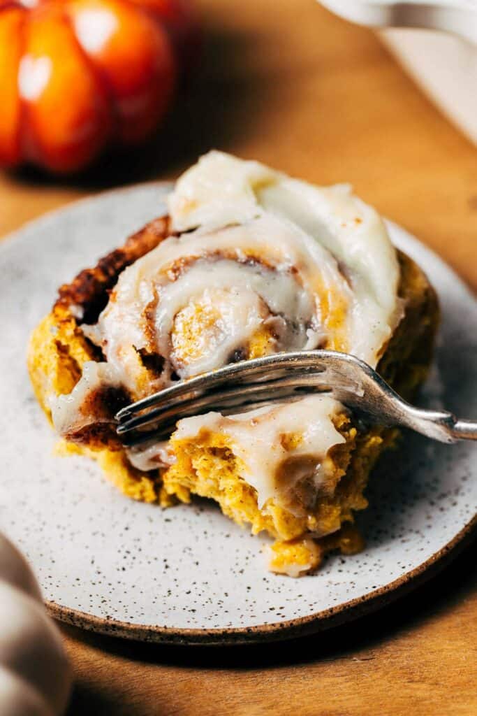 digging a fork into a pumpkin cinnamon roll