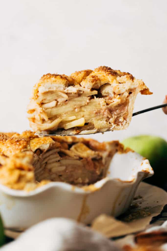 lifting a slice of apple pie out of the pie