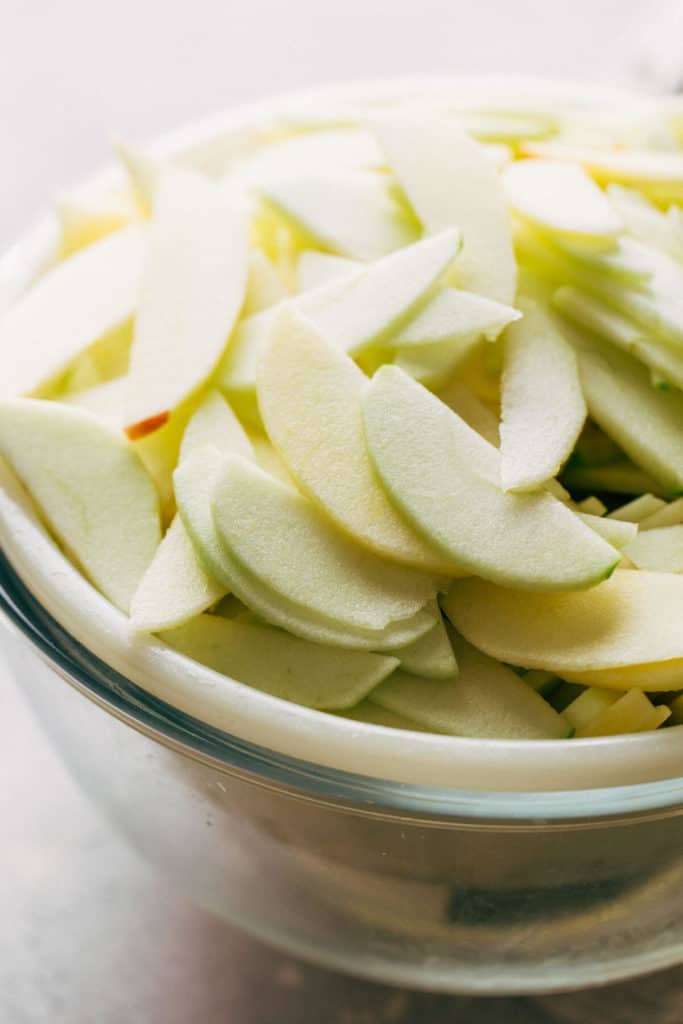 slices of apples in a colander over a bowl
