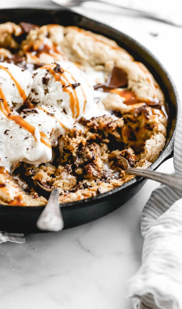 a gluten free skillet cookie with ice cream and caramel on top