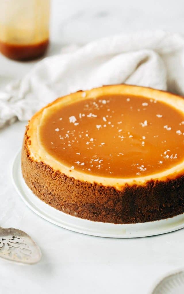 side angle of a caramel cheesecake topped with a pool of salted caramel