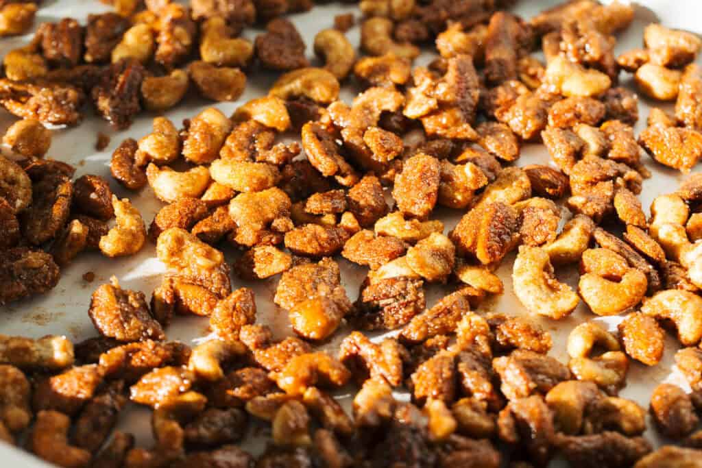 process shot of candied nuts on baking sheet before baking