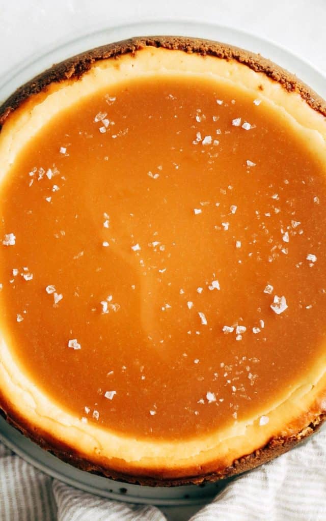 close up on the top of a caramel cheesecake topped with a pool of salted caramel