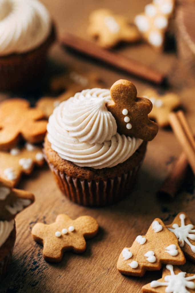 close up on a gingerbread cupcake topped with a mini gingerbread cookie