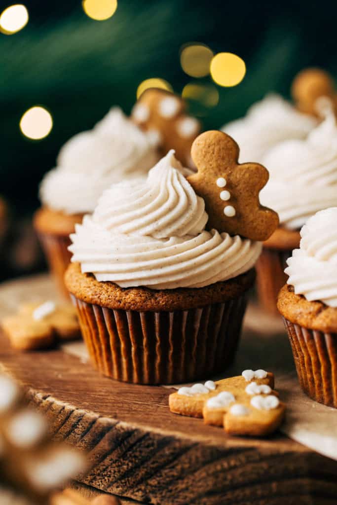 close up on a gingerbread cupcake topped with a mini gingerbread cookie