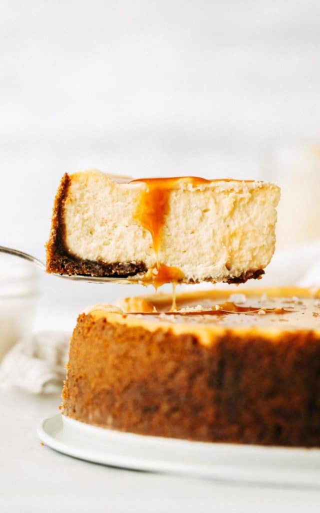 lifting out a slice of salted caramel cheescake