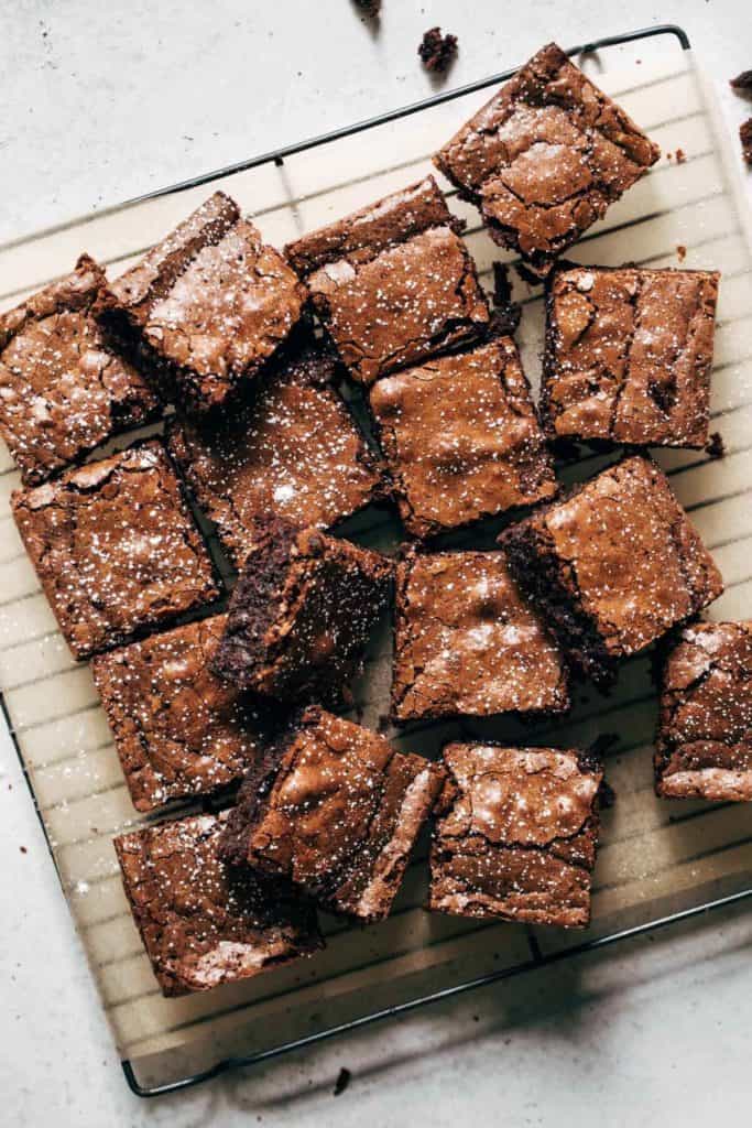 a tray of sliced brownies sprinkled with powdered sugar