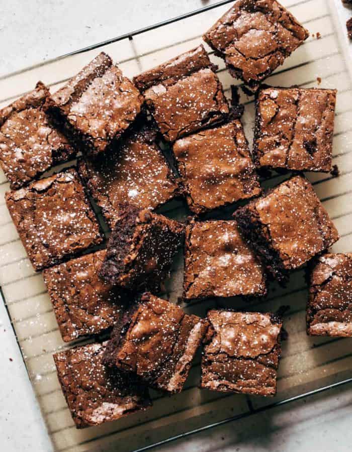 a tray of sliced brownies sprinkled with powdered sugar