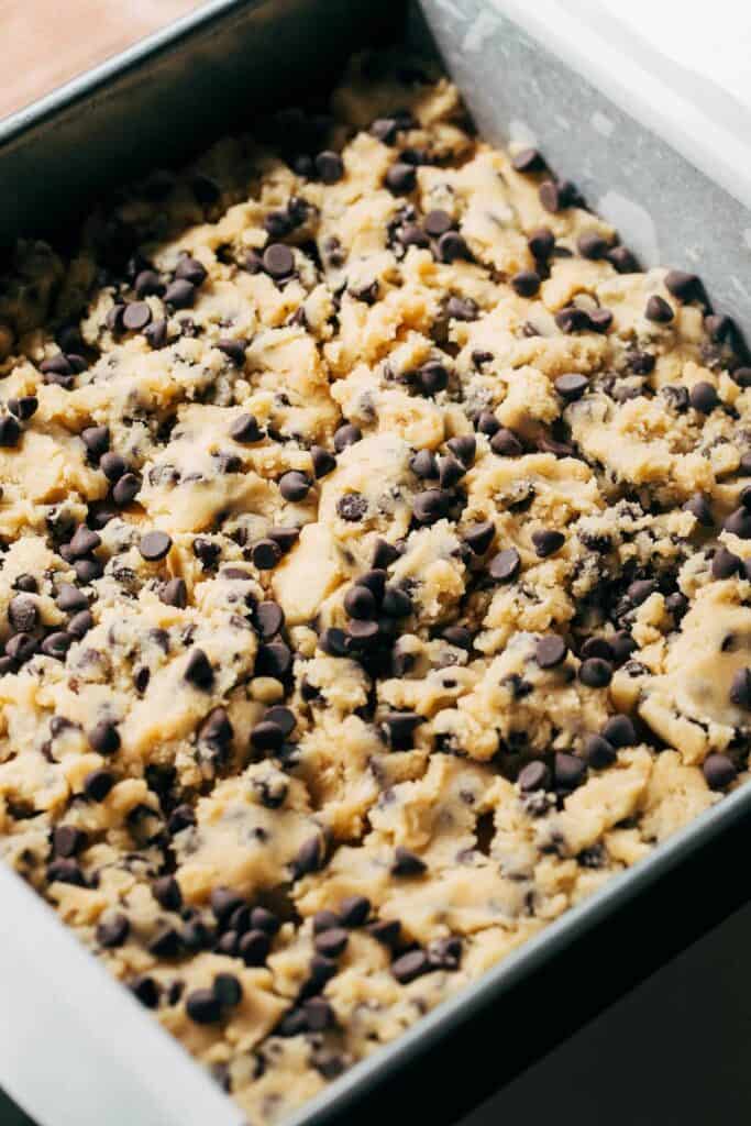 chocolate chip cookie dough crumbled on top of a layer of cookie butter