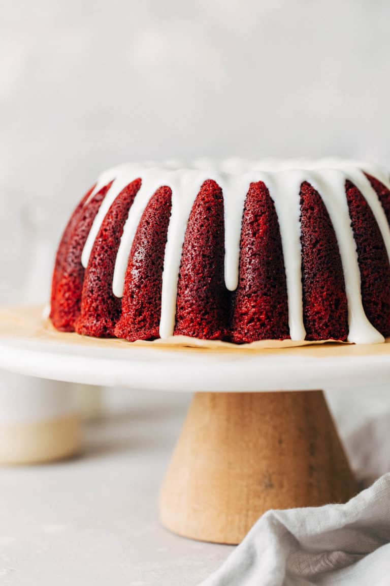 red velvet bundt cake from the side with glaze dripping down