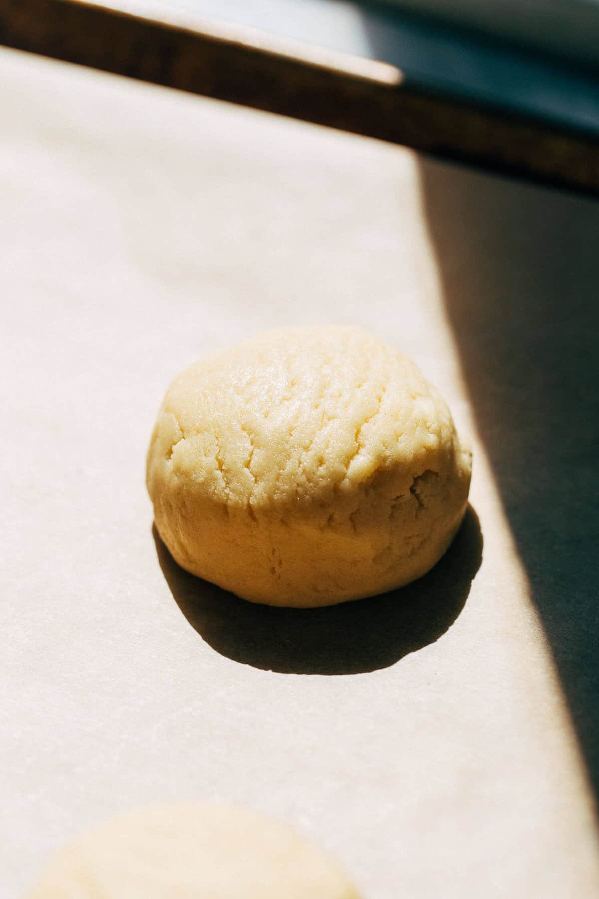 a sugar cookie dough ball on a baking pan