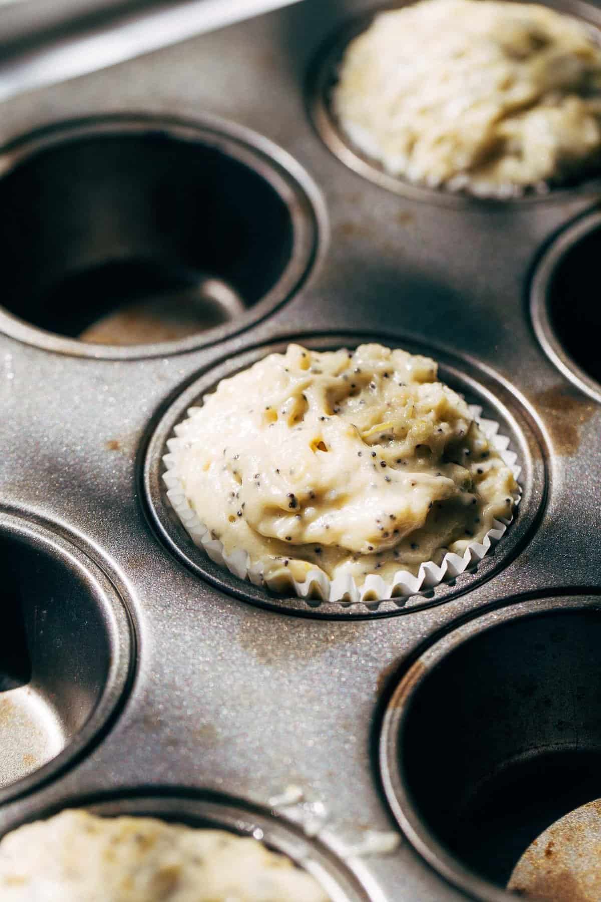 lemon poppy seed muffin batter scooped in a cupcake tin